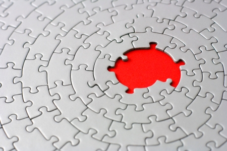 grey jigsaw with missing pieces in the red center